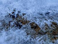 Spitze Eisstrukturen versuchen sich überm Bach zu schließen